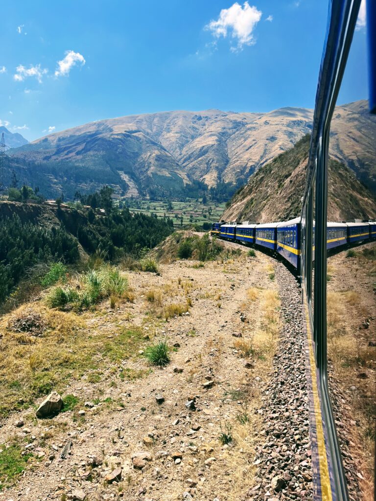 Kelionė į Peru: Maču Pikču, Amazonė ir praktiniai patarimai Panoraminis Andų kalnų peizažas važiuojant prabangiu traukiniu maršrutu iš Kusko į Puną, link Titikakos ežero.