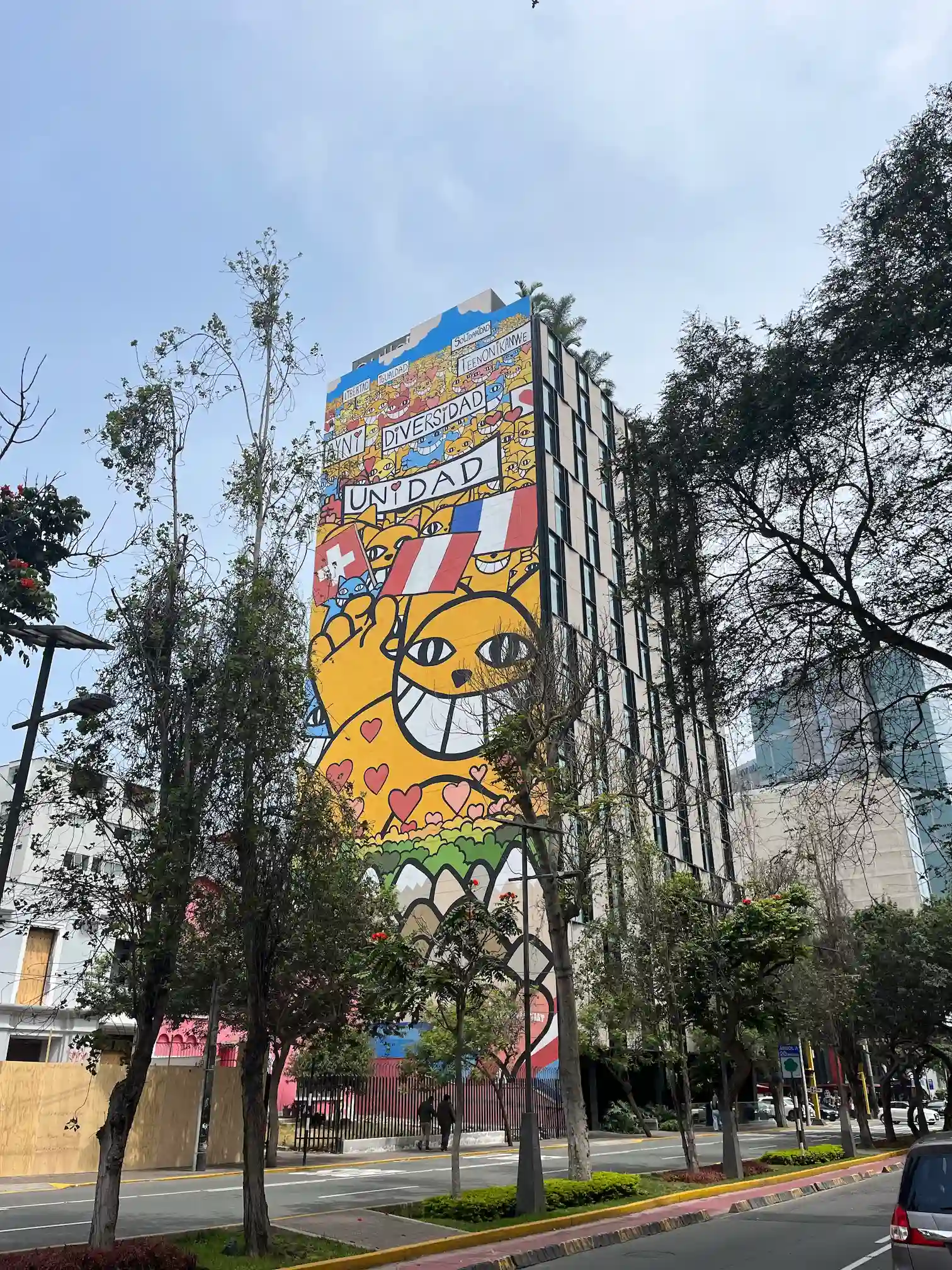 Muralis su šypsančiu veidu ir užrašu „Unidad" ant daugiabučio, Miraflores, Lima