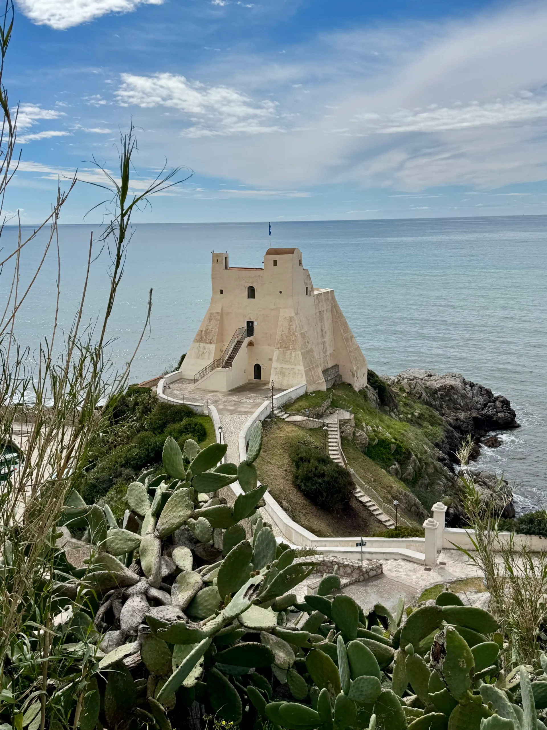 Sperlonga tvirtovė Torre Truglia ant uolos virš jūros, priešplane — kaktusai ir Tirėnų jūra