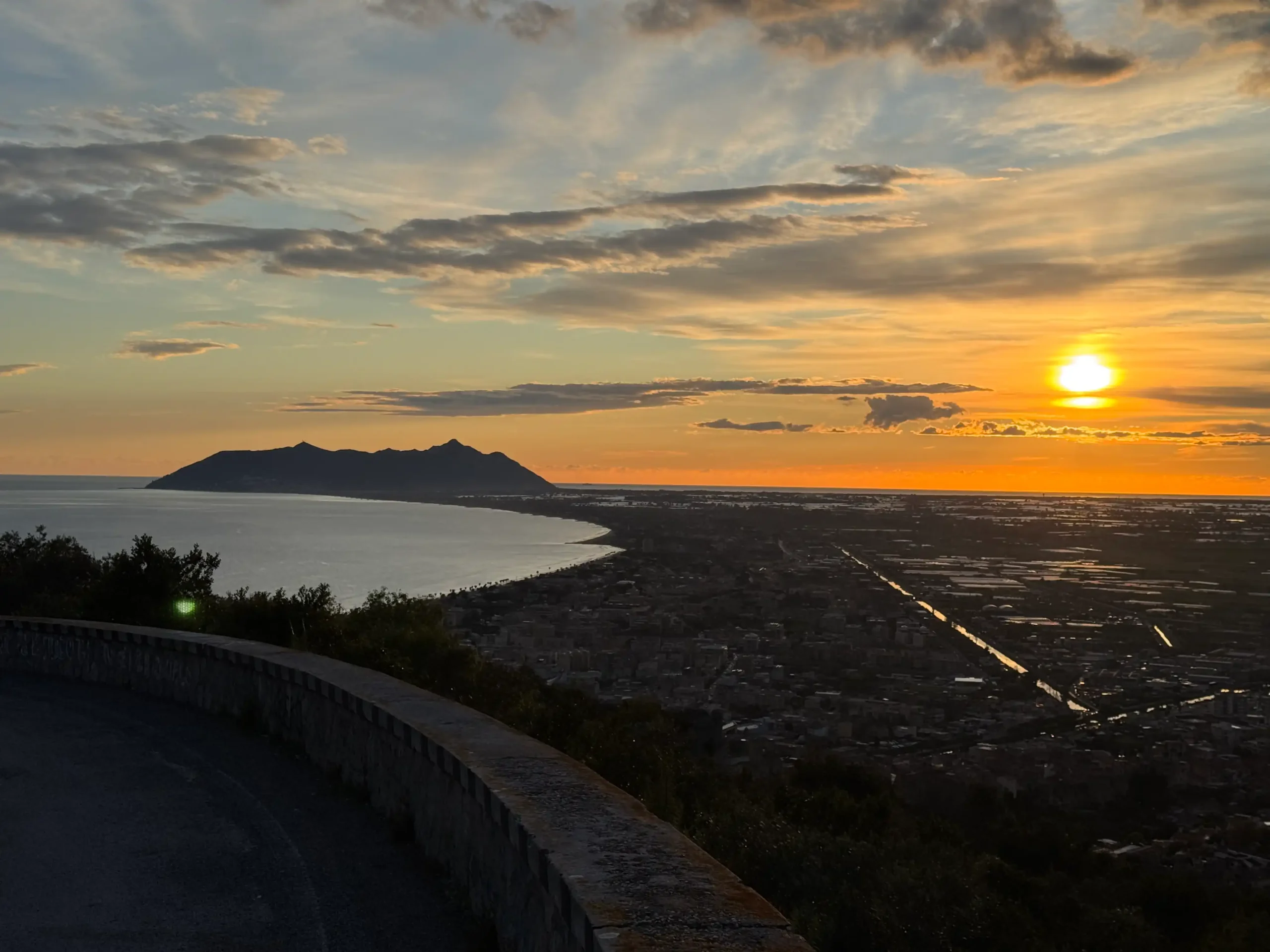 Saulėlydis virš Terracinos ir Circejos kyšulio — panoraminis vaizdas iš kalno su jūros pakrante
