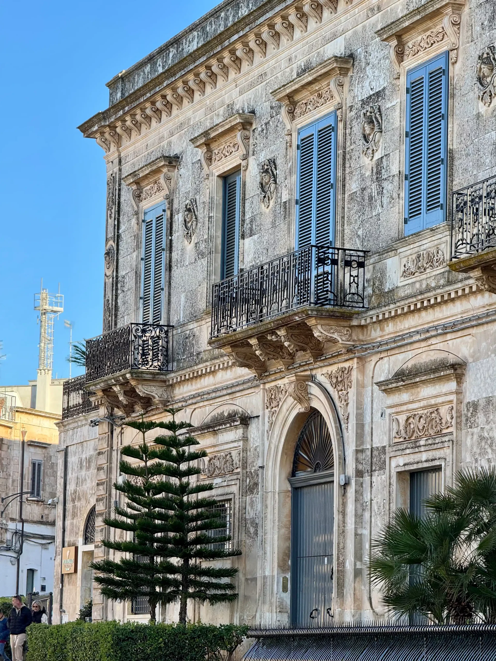 Istorinis barokinis pastatas iš balto akmens su ornamentuota fasado puošyba, langiniais ir geležiniais balkonais Puglijos mieste