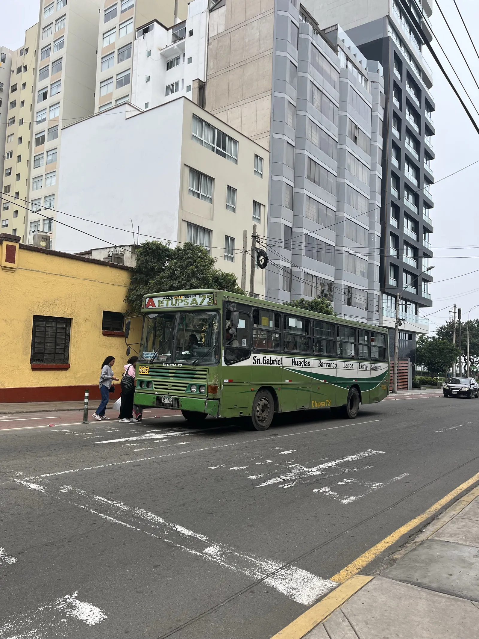 Senas žalias miesto autobusas Etupsa 73 Limos gatvėje, keleiviai lipa prie geltono namo