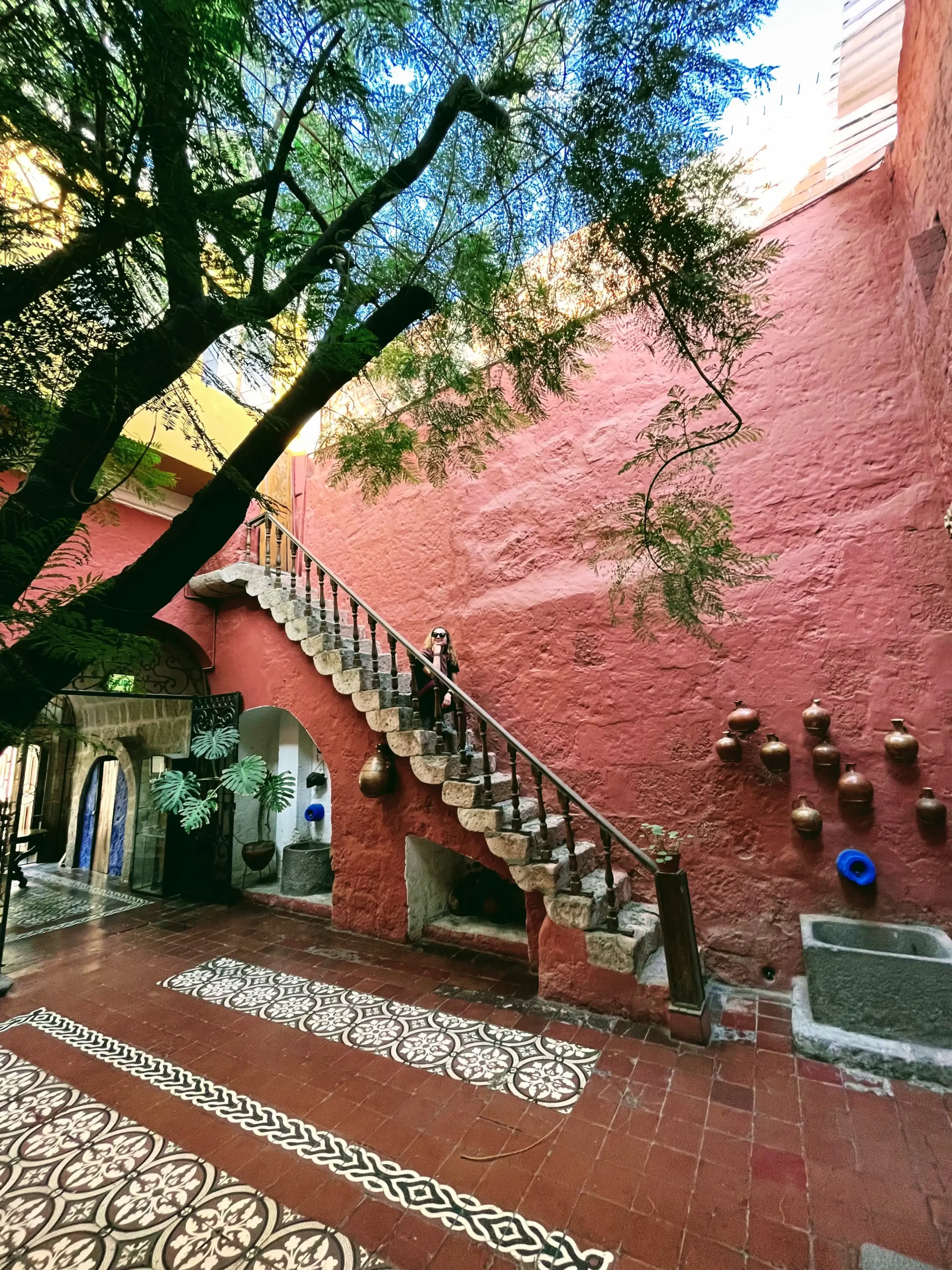 Raudona vidinė kiemo siena ir akmeniniai laiptai Santa Catalina vienuolyne Arekipoje