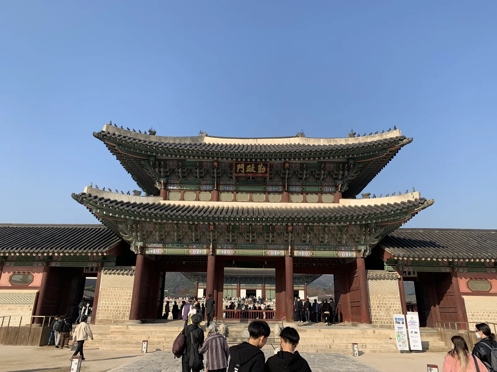 Gwanghwamun vartai prie Gyeongbokgung rūmų Seule, priešais vaikštantys turistai
