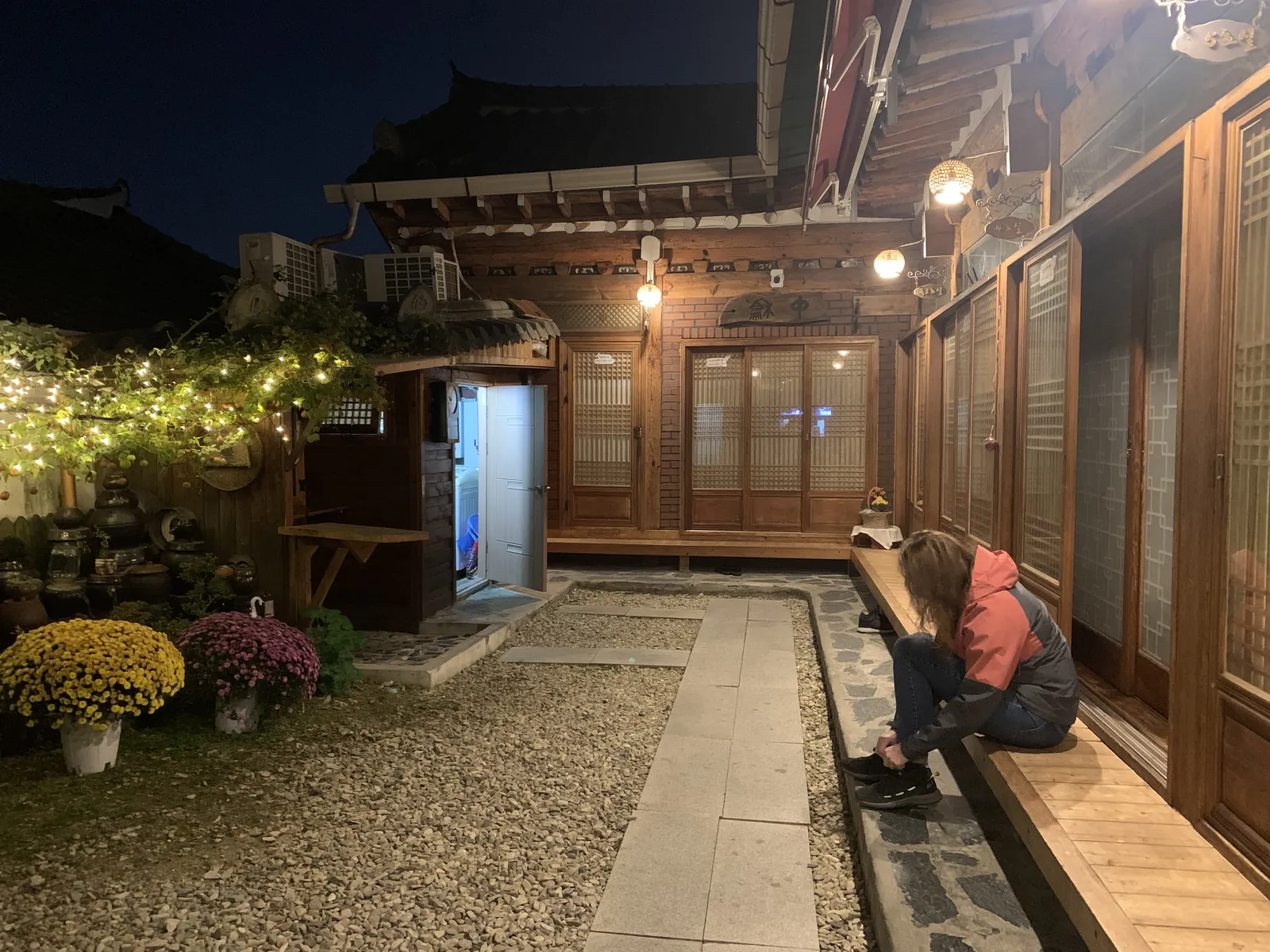 Apšviestas hanok svečių namų kiemas vakare Pietų Korėjoje