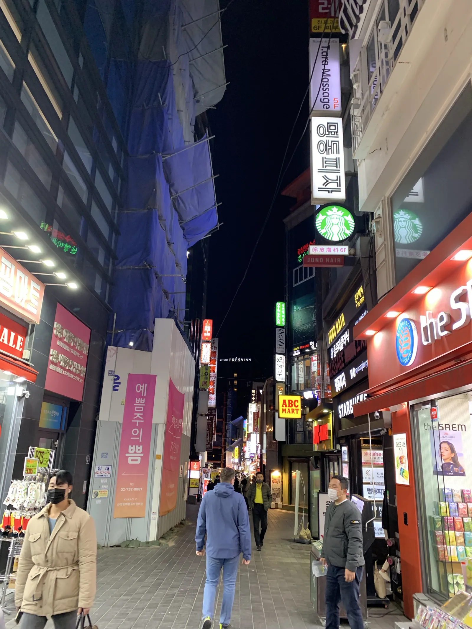 Myeongdong prekybos gatvė Seule vakare su šviečiančiomis iškabomis